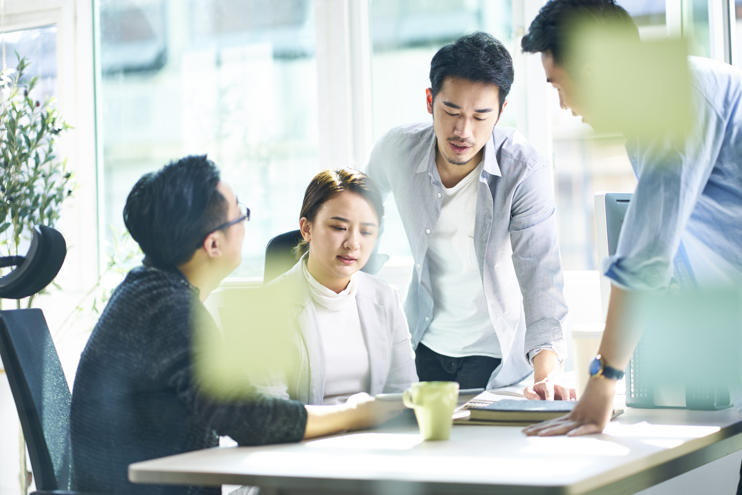 group of four young corporate executives meeting in office